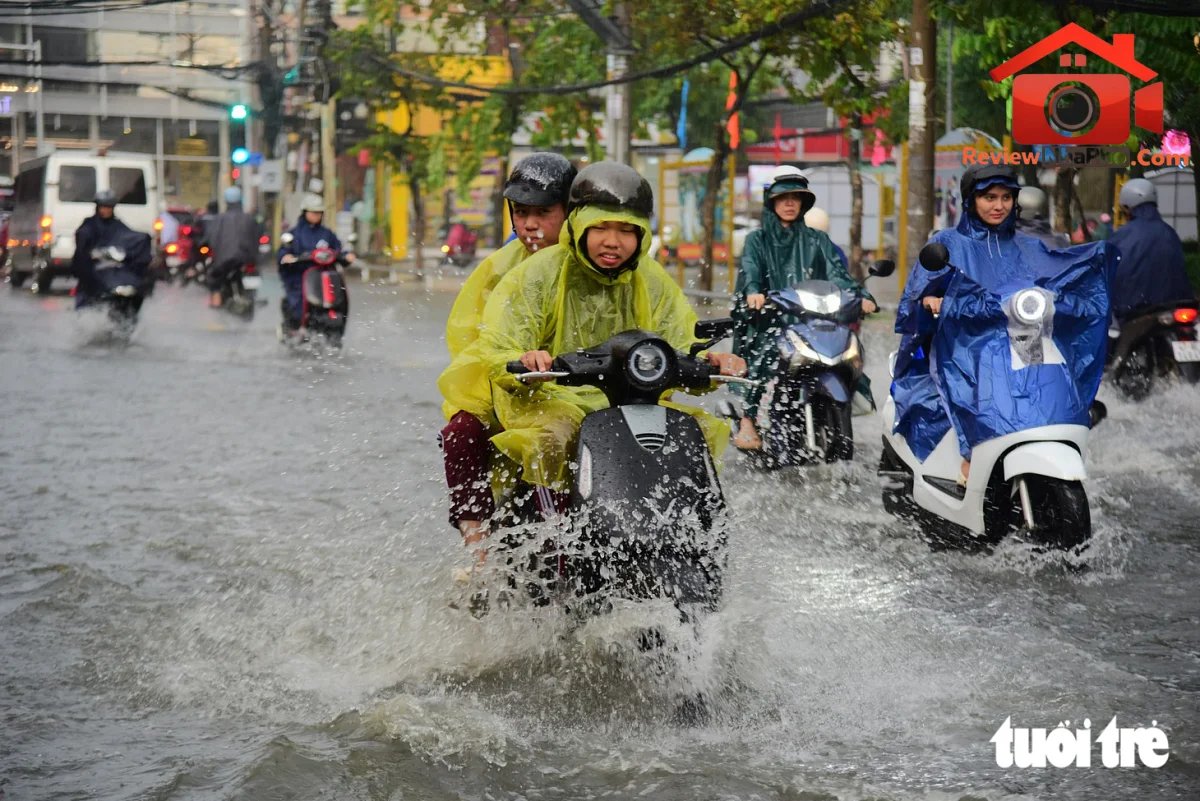 Ngã tư Nguyễn Văn Khối - Lê Văn Thọ ở TP.HCM ngập sâu, học sinh dắt xe lội nước về nhà - Ảnh 1.